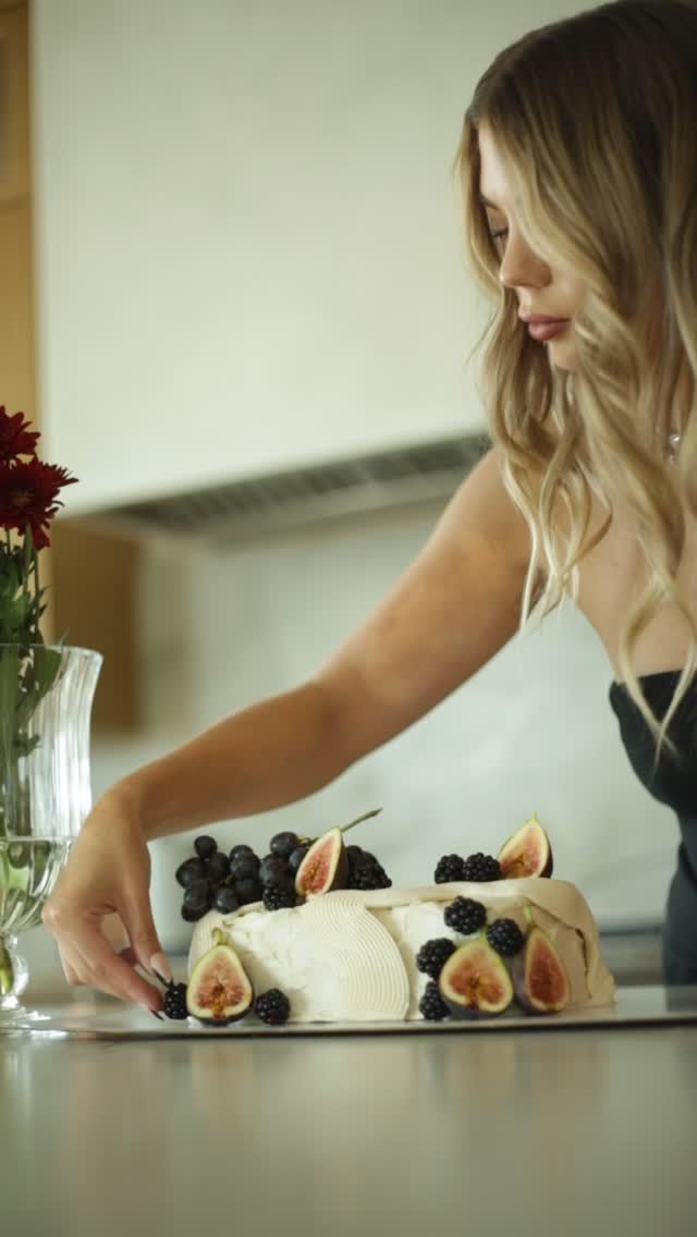 Bat City Bakes owner styling a white buttercream cake with fresh figs and berries, Austin TX