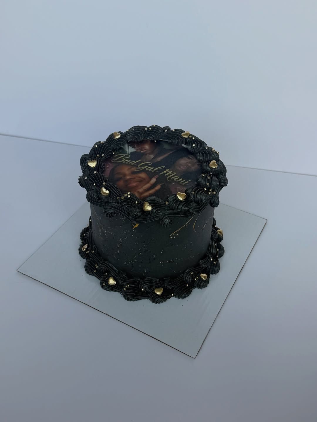 Sleek black Lambeth cake with a vintage portrait print and gold accents, Austin TX