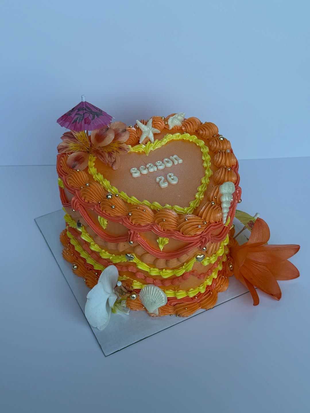 Orange tropical beach heart cake with a cocktail umbrella and starfish, Austin TX